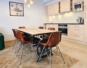 A modern kitchen with wooden cabinets, a stainless steel microwave, and a coffee maker.