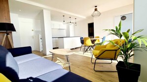 Un salon moderne avec un canapé, une table à manger et des chaises jaunes.