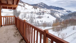 A wooden balcony with a view of a snowy mountain landscape. - Cozy apartment at the slopes with pool (Flumet)