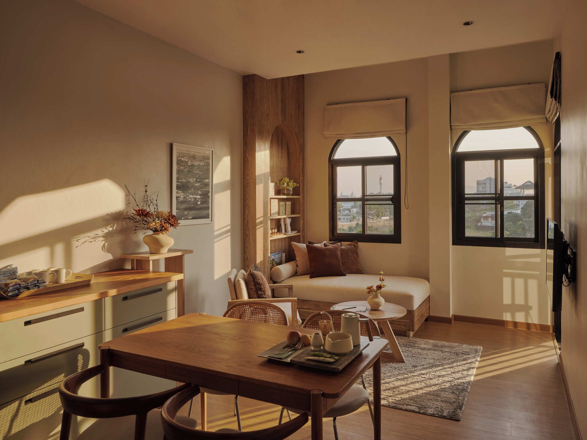 Una sala de estar acogedora con comedor, un sofá y una ventana con vistas a edificios.