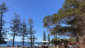A park with playground equipment, a fenced area, and a view of the sea. - Boudoir on Bryce St - (Pet Friendly to ONE, SMALL non hair shedding dog 4.5kg) (Moffat Beach)