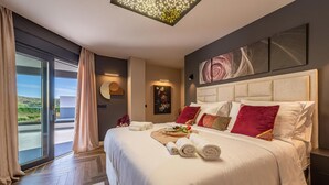 Ein modernes Hotelzimmer mit einem großen Bett, Blick ins Freie und einer Deckenleuchte.