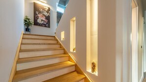 Eine Treppe mit Holzbodenstufen und Wandleuchten.