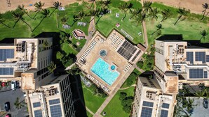 An aerial view of a resort with a swimming pool, palm trees, and beach access. - Sugar Beach PH21 - Direct Oceanfront 1 bedroom (Kihei)