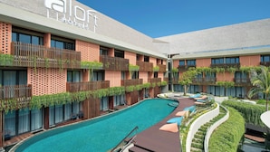 A hotel with a swimming pool, outdoor seating, and a modern design. - Aloft by Marriott Bali Kuta at Beachwalk (Kuta)