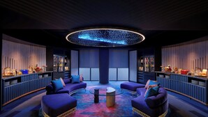 A modern lounge area with purple seating, a central coffee table, and a neon ceiling light. - Aloft by Marriott Bali Kuta at Beachwalk (Kuta)