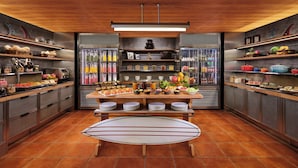 A kitchen with a central island, shelves with various food items, and a refrigerator. - Aloft by Marriott Bali Kuta at Beachwalk (Kuta)