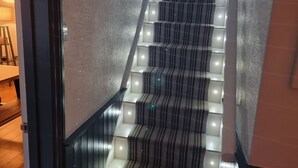 Escales il·luminades i un davallamb carpetes a ratlles.