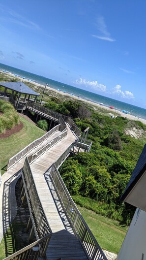 A wooden boardwalk leading to a beach with a clear view of the ocean. - Beachfront resort, family friendly amenities *** SHIBUMI rental included*** (Atlantic Beach)