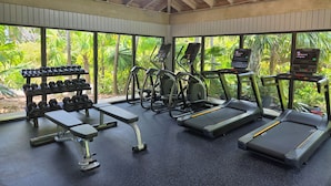 Ein Fitnessstudio mit Laufbändern, Crosstrainern und Kurzhanteln.