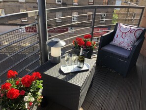Relax on the balcony with a wicker chair and a small table, perfect for enjoying a glass of wine and taking in the view.