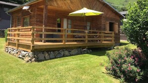 Eine Holzhütte mit Veranda und einem gelben Sonnenschirm.