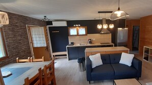 Ein kompakter Wohnraum mit Küchenzeile, Essbereich und einer Sitzecke inklusive Sofa und Sesseln.