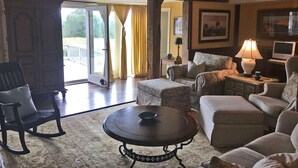 Un salon spacieux doté d’une grande fenêtre, d’une cheminée et d’un coin salon confortable.