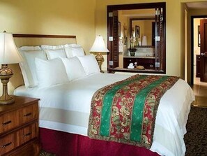 Cozy retreat with a neatly made bed, wooden nightstand, and stylish throw.