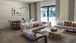 Ein geräumiges Wohnzimmer mit Essbereich, einer Sofagarnitur und einem Holztisch.