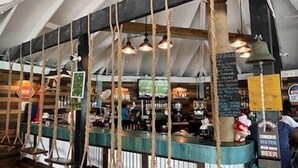 A rustic bar area with wooden beams, rope swings, and hanging lights. - Exuma Sol - Stunning Views from this Oceanfront Beach Cottage (George Town)