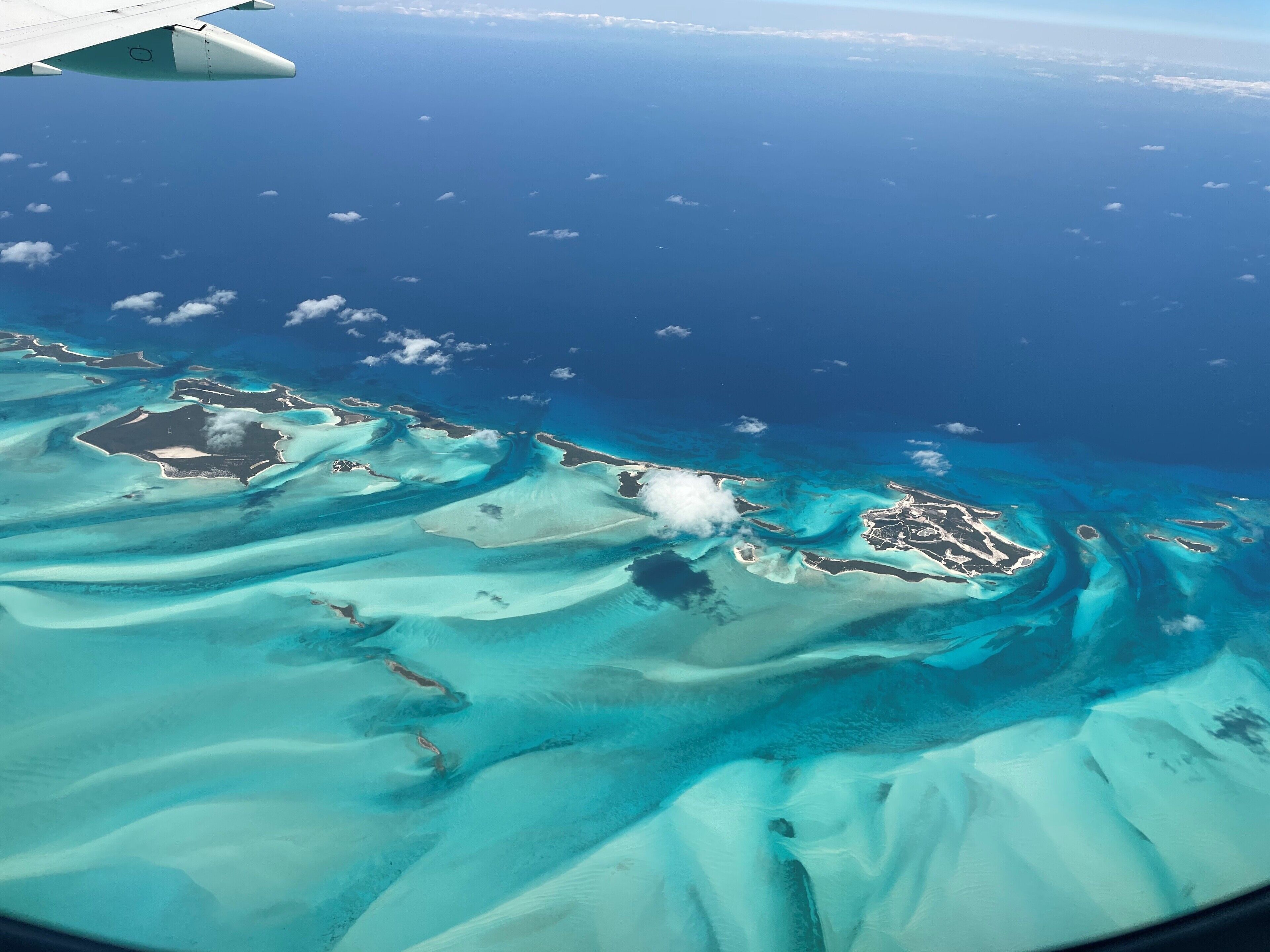 An aerial view of a tropical island with clear turquoise waters and sandy beaches.