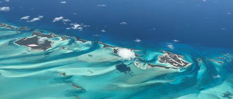 An aerial view of a tropical island with clear turquoise waters and sandy beaches.