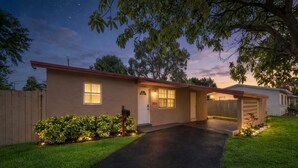 A single-story house with a front entrance, a mailbox, and a driveway leading to the garage. - Spacious 5BR Getaway-Great for Families & Groups (Lauderdale Lakes)