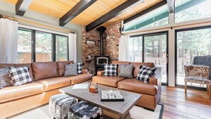 A spacious living room with a leather sectional sofa, a coffee table, and a fireplace.