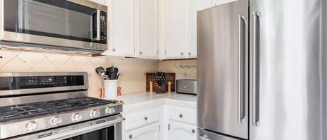 A modern kitchen with stainless steel appliances, including a microwave, oven, and refrigerator.