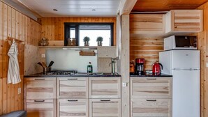 A compact kitchen with wooden cabinetry, a stove, and a refrigerator. - Charming 2-bed Cottage Near Seljalandsfoss (Rangárþing eystra)