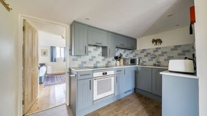 A modern kitchen with grey cabinets, a built-in oven, and a microwave.