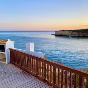 Overlooking the calm sea, this property features a deck with a railing, perfect for taking in the ocean views.