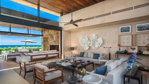 A spacious living area with a large window overlooking a scenic view, a ceiling fan, and a mix of modern and traditional furnishings.