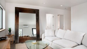 A modern living room with a glass coffee table, white sofa, and a large mirror. - Modern Apt w/ Mt Views & Grill Near Basalt & Aspen (Basalt)