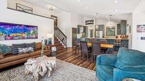 Un salon moderne comprenant un canapé, une table basse et un coin repas avec des chaises et une table.