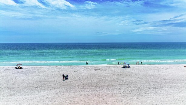 Ein Strand mit blauem Himmel und ruhiger See.
