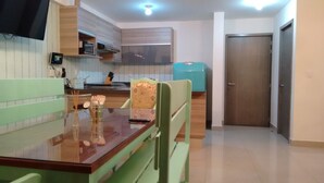 Una cocina compacta con una mesa de comedor, sillas, un microondas y un armario.