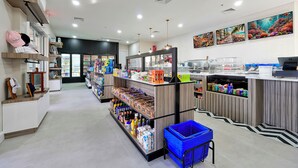 A clean, well-lit grocery store with shelves stocked with various products, a blue shopping basket, and a refrigerator in the background. - Windsor Hills Waterpark Community, NEW 2025 Game Room! Pool/Spa, Disney Rooms (Kissimmee)
