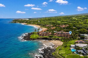 A coastal resort with multiple buildings, a beach, and a clear view of the ocean.