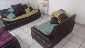 A room with a sofa, a chair, and a small table.