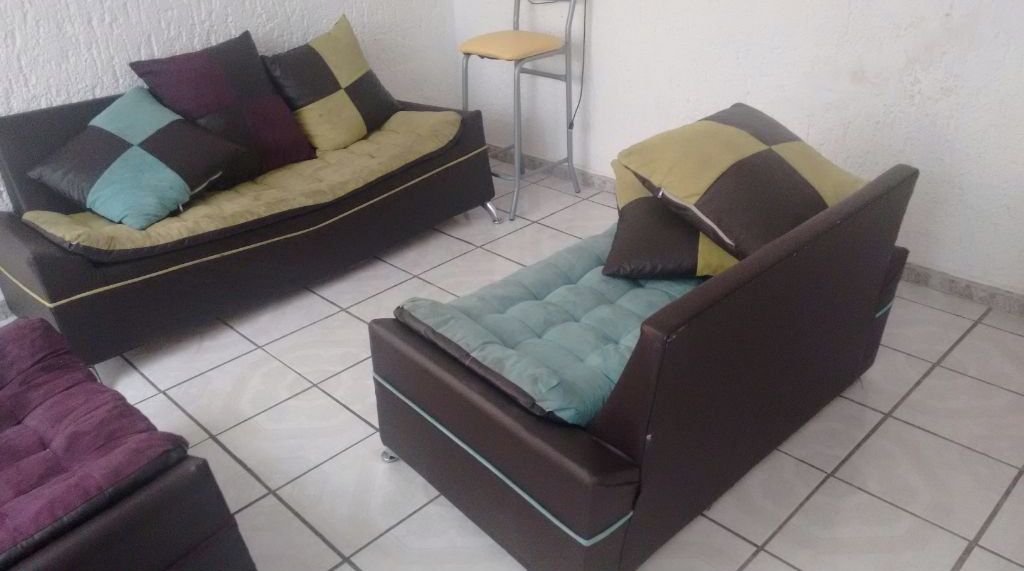 A room with a sofa, a chair, and a small table.