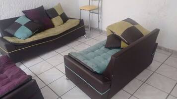 A room with a sofa, a chair, and a small table.