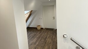 A modern interior with a wooden ceiling, a staircase, and a door marked with the number 6.