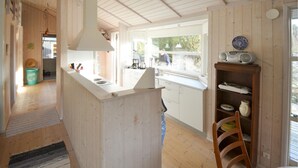 Una cucina moderna con isola centrale, mobili in legno e vista sull'esterno.