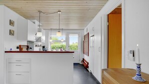 A modern kitchen with white cabinets, a wooden ceiling, and pendant lighting. - 3 bedroom pet friendly home in Hejls (Hejls)