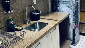 A kitchen with granite countertops, a stainless steel sink, and a refrigerator with a decorative design. - Stay here! Stay here! 2/4 furnished apartment in Costa Azul :-) (salvador)