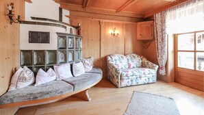 Una habitación acogedora con un banco de madera, un sofá floral y un mueble decorativo.