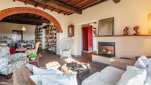 A cozy living room with a fireplace, bookshelves, and comfortable seating. - 3 bedroom gorgeous home in Greve in Chianti (Greve in Chianti)