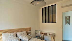 A bedroom with a bed, bedside tables, a desk, and a chair. - T2 Liberté 3 minutes from beaches, shops and train station (Saint-Raphaël)