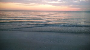 A beach with gentle waves and a clear sky.