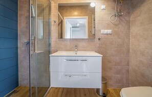 A modern bathroom with a glass shower enclosure, a white vanity with a mirror, and a toilet. - Cozy home in Rewal with heated swimming pool (Rewal)