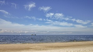 Una playa con arena y mar tranquilo.