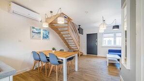 Una cocina moderna con una mesa y sillas de madera, una escalera y un rincón comedor con un banco.